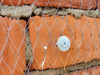 Double-layer stucco mesh is fixed on brick wall by big head nail.