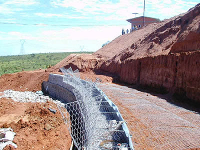 A row of green gabion basket is placed on the bare slope.