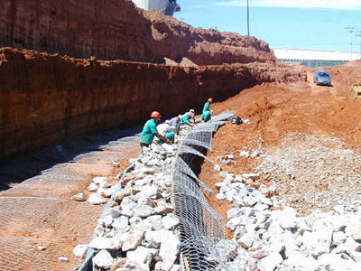 Workers are fill rocks into the galvanized green gabion basket.