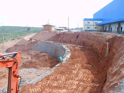 A worker is layering soil on the retaining wall.
