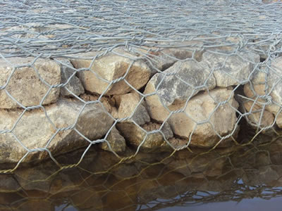 Some stones are placed in gabion basket soaking in water.