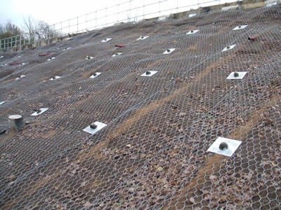 Hexagonal wire mesh is applied upon coir fiber netting, with nails on the surface to fix both of the netting.
