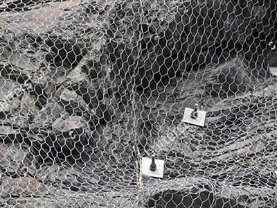 Three pieces of hexagonal wire mesh is jointed together on a slope surface.