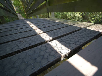 On a wooden bridge, hexagonal wire mesh is used on its path surface.