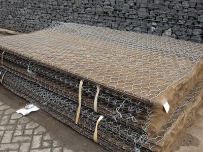 Several trapezoidal gabion baskets are lying besides a welded gabion.