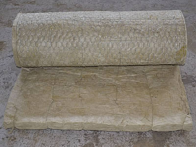 A roll of hexagonal wire mesh attached rock roll is lying on the ground.