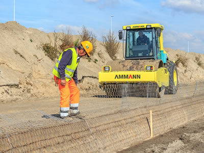 A worker and a rolled car is compacting the filled soil.