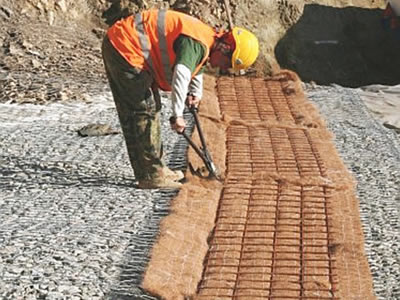 A worker is combining welded wire meshes of different terramesh panels into the an integral one.
